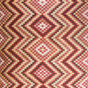 Red, black, gold, and gray flatweave rug with a repeating geometric serrated diamond pattern.