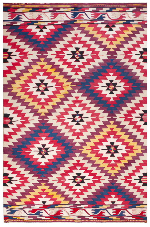 Flatwoven rug in bold red, blue, purple, and yellow stepped geometric designs on a cream field.
