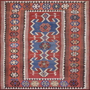 Terracotta and blue flat-woven rug with a central geometric zigzag design and repeating medallion borders.