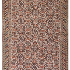 Cream rug with a busy traditional pattern in deep red, burnt orange, brown, and navy accents.