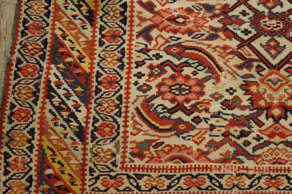 Detailed flat-weave rug in cream, red, blue, and yellow with intricate geometric and floral motifs.