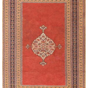 Red-orange field rug with a detailed central geometric medallion and multi-banded navy and gold borders.