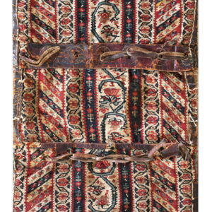 Vertical striped textile panel in red and black florals, secured with two aged brown leather straps.