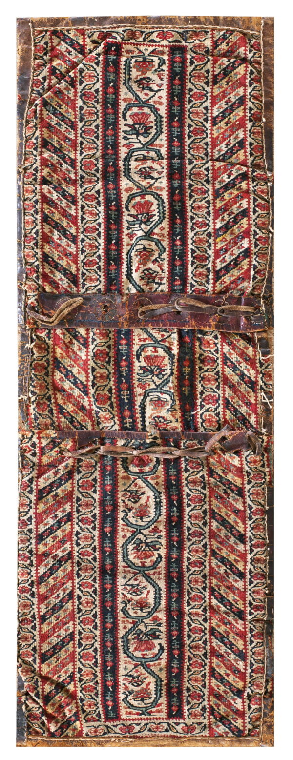 Vertical striped textile panel in red and black florals, secured with two aged brown leather straps.