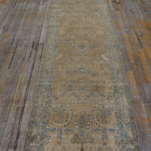 Traditional gold runner with faded blue patterns rests on distressed wooden floorboards.