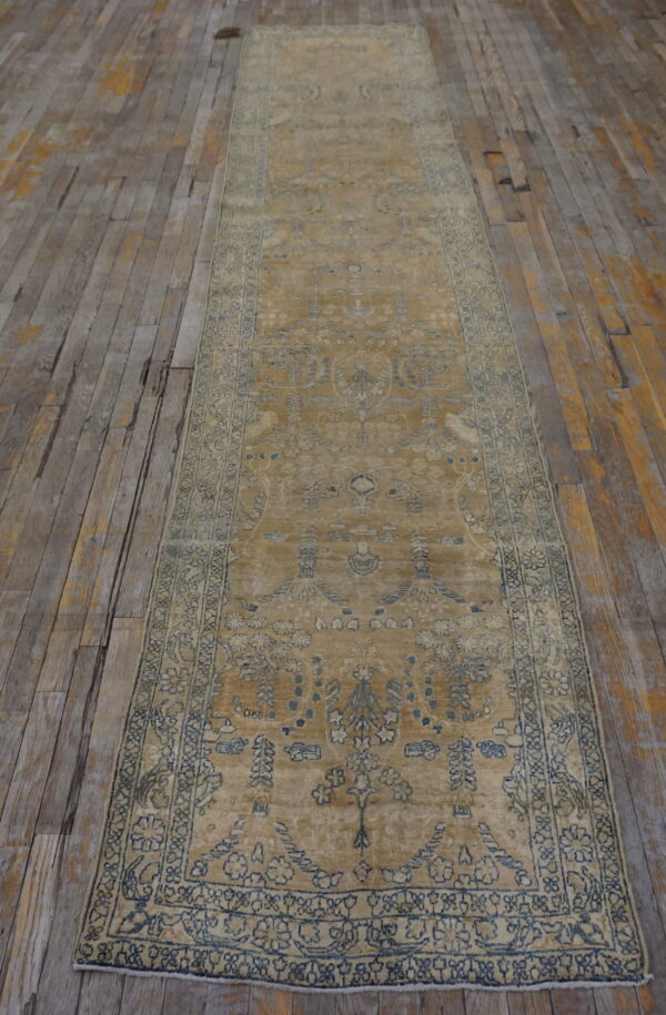 Traditional gold runner with faded blue patterns rests on distressed wooden floorboards.