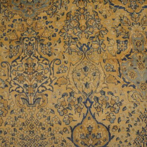 Low pile rug showing a detailed floral medallion pattern in golden yellow, navy blue, and light blue.