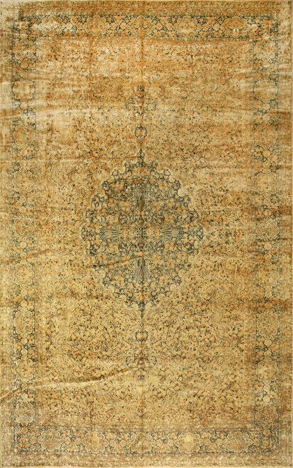 Distressed traditional rug in faded gold and amber tones with dark blue floral motifs and a center medallion.