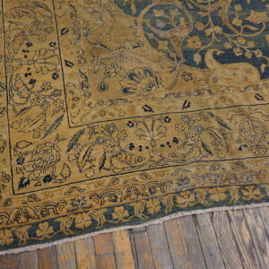 Golden yellow border with blue floral details meets a darker blue field on a distressed wooden floor.