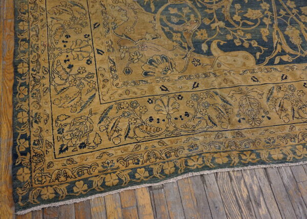 Golden yellow border with blue floral details meets a darker blue field on a distressed wooden floor.