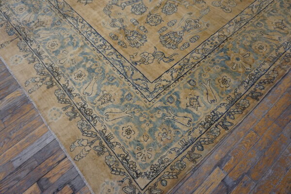 Gold and pale blue traditional rug featuring a detailed floral and vine border on rustic wood planks.