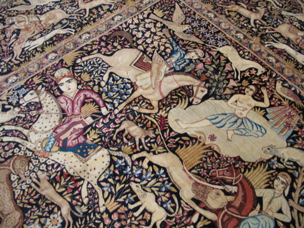 Detail of a densely patterned rug with dark ground, showing colorful figures, horses, and animals among floral vines.