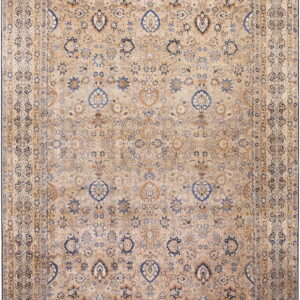 Tan and beige low-pile rug with complex traditional floral designs in dark blue and light brown.