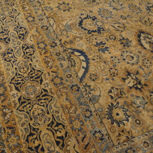 Ornate gold and navy floral rug featuring wide borders and a distressed low pile texture.