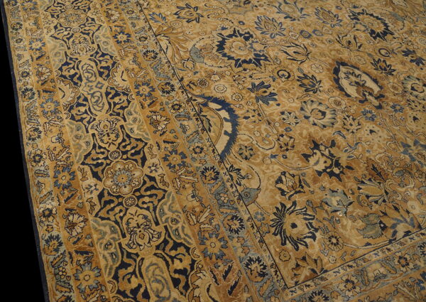 Ornate gold and navy floral rug featuring wide borders and a distressed low pile texture.