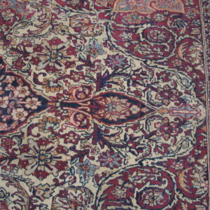 Traditional rug pattern in deep burgundy, navy, and cream featuring intricate florals and a vertical border.