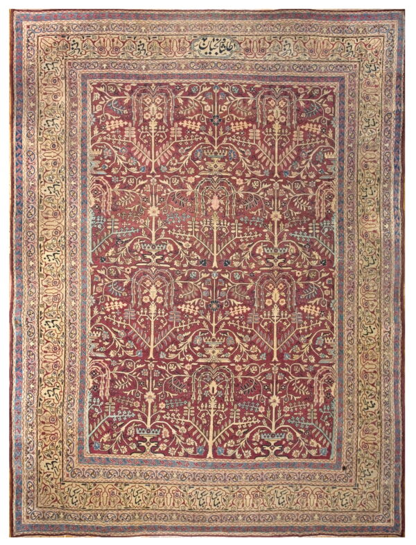 Low-pile area rug featuring a dense red botanical pattern and complex tan and blue borders with script elements.