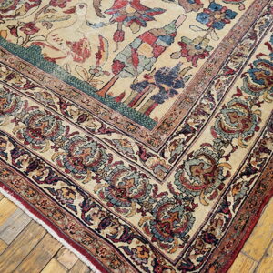 Traditional beige rug with wide floral borders in red and blue, displayed on golden wood planks.