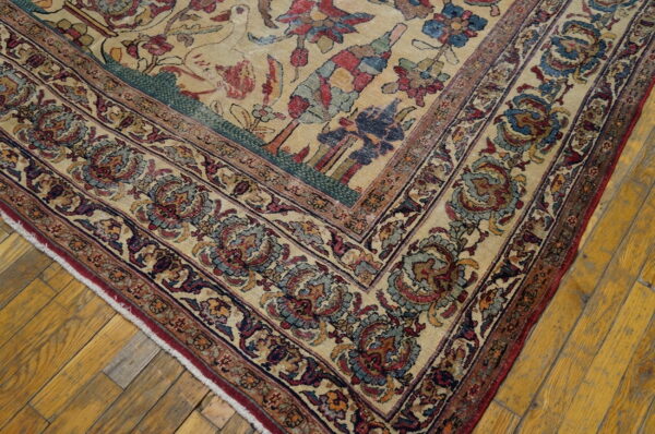 Traditional cream rug corner showing detailed red, blue, and teal borders on yellow wood floors.