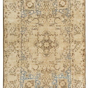 A rectangular beige rug with a distressed traditional medallion and faded blue and brown floral patterns.