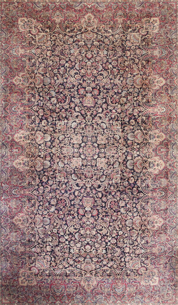 Densely woven traditional rug featuring an all-over floral and vine pattern on a dark navy and rose background.