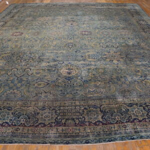 Oversized traditional rug with a detailed blue, teal, and navy floral pattern on hardwood flooring.