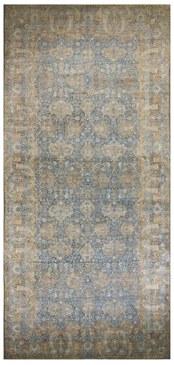 Distressed traditional rug in blue and muted gold tones featuring an intricate faded floral design.