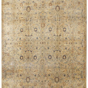 Low-pile traditional area rug featuring complex faded floral patterns in beige, tan, and muted blue.