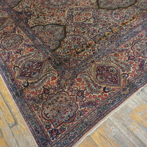 Traditional rug with detailed blue and red floral patterns lies on distressed yellow and gray wood flooring.
