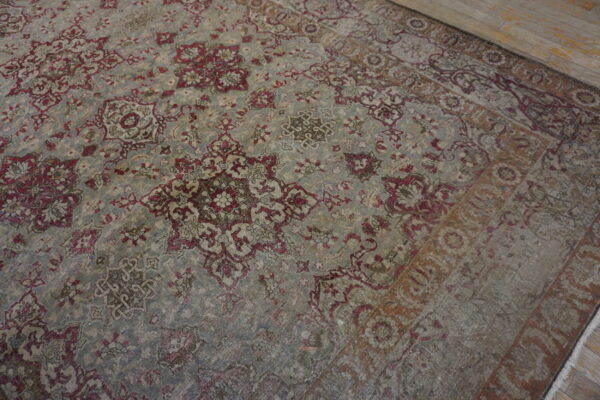 Distressed blue-gray rug with burgundy and beige traditional floral patterns on light wood flooring.