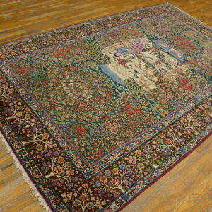 Detailed rug with a green floral field, burgundy border, and cream pictorial panel on distressed wood floorboards.
