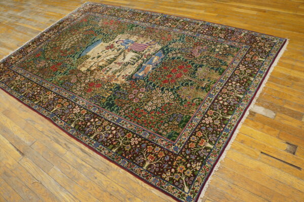 Multicolored tree of life area rug with a detailed central figural scene, displayed on rustic light wood flooring.