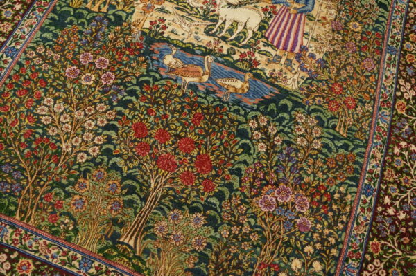 Green rug featuring a detailed pictorial pattern of red and white flowers, lush trees, water, and birds.