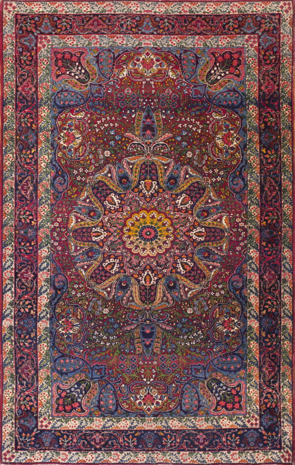 Detailed traditional rug with a deep red center field, a navy border, and colorful floral ornamentation.