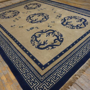 Tan rug featuring navy blue circular mythological motifs and Greek key borders on weathered wood floorboards.