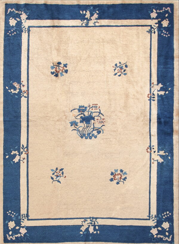 Light beige rug with a wide dark blue border and traditional blue and rust floral designs.