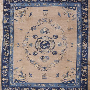 Beige rug with dark blue borders and light blue floral and pictorial motifs.