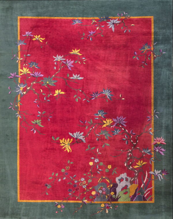 A deep red rug with a teal border and scattered flowering vines in yellow, purple, and gray.