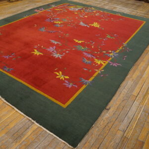 Red and green rug featuring scattered yellow, purple, and blue floral motifs on worn wooden planks.