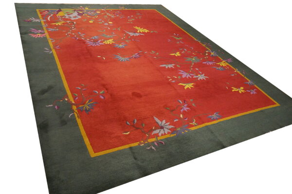 Rectangular rug with a red center panel, colorful vines, a yellow stripe, and a dark green border.