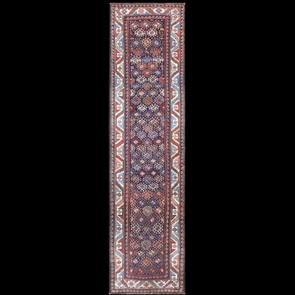 Long runner rug showcasing a detailed geometric pattern in navy, rust, blue, and white tones.