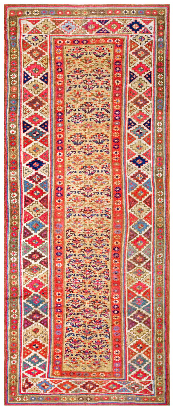 Multicolored flatweave runner featuring a tan central panel of floral designs and bold red geometric borders.