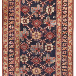 Narrow rug with a navy field, red, tan, and light blue geometric patterns, and multiple banded borders.