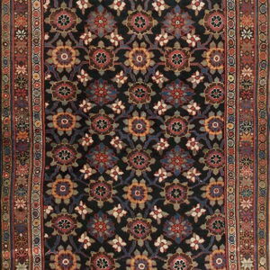 A traditional rug featuring a dark field with repeating multicolored floral medallions and a complex, highly detailed border.
