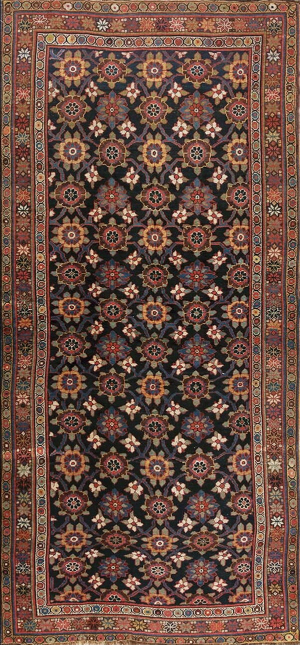 A traditional rug featuring a dark field with repeating multicolored floral medallions and a complex, highly detailed border.