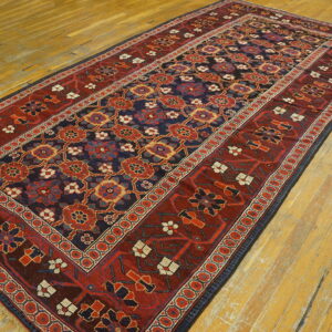 Red and navy traditional runner rug displayed on wide plank, yellow-toned hardwood floors.