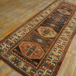 Dark brown runner with large geometric medallions and a patterned border rests on distressed yellow wood floorboards.