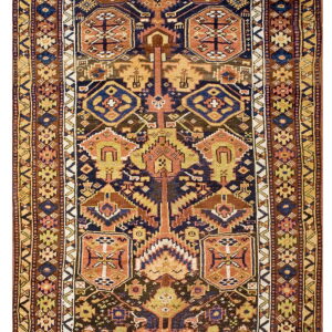 Close-up of a runner rug with a tribal geometric pattern in indigo, rust, mustard, and brown.