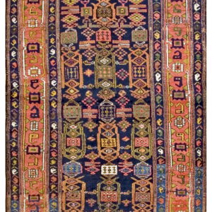 Navy blue rug with geometric tribal medallions and a wide coral pink border.