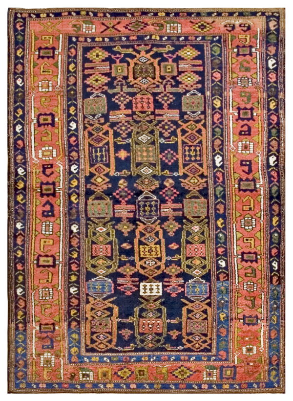 Navy blue rug with geometric tribal medallions and a wide coral pink border.